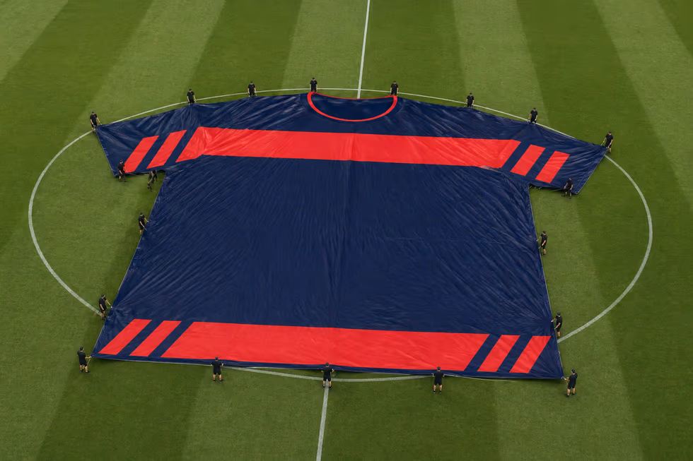 Maillot géant personnalisé navy et rouge déployé sur la pelouse par des porteurs